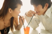 Couple sharing one drink, sitting face to face - Alex Microstock02