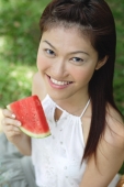 Woman holding slice of watermelon, smiling at camera - Alex Microstock02