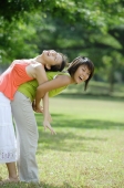 Two young women, back to back, one bending forward - Wang Leng