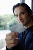Man holding credit card, smiling at camera - Yukmin