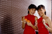 Young women dressed in red, holding two oranges and red packet - Alex Microstock02