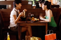 Two young women having a meal in restaurant - Alex Microstock02