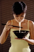 Young woman eating a bowl of noodles - Alex Microstock02