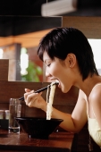 Young woman in restaurant, eating a bowl of noodles - Alex Microstock02