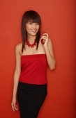 Young woman in red tube top holding perfume bottle - Yukmin