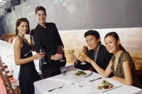 Couples in restaurant, holding wine glasses, smiling at camera - Alex Mares-Manton