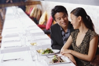 Couple in restaurant, sitting side by side, looking at each other - Alex Mares-Manton