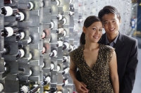 Couple standing in wine cellar, looking at camera - Alex Mares-Manton