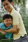 Father carrying son, both smiling - Yukmin