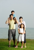 Family of four, standing by sea, family portrait - Yukmin