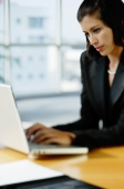 Businesswoman dressed in black, using laptop - Alex Mares-Manton