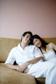 Couple lounging on sofa, looking at camera - Yukmin