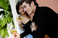Couple standing in balcony with wine glasses - Yukmin