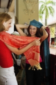 Two women shopping trying on shawls and scarves - Alex Microstock02