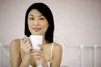 Woman holding cup, looking at camera - Yukmin