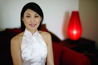 Woman dressed in Chinese cheongsam, smiling at camera - Yukmin