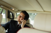 Businessman sitting inside car, using mobile phone - Alex Mares-Manton