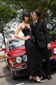 Well dressed couple standing in front of red car - Alex Mares-Manton