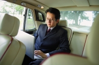 Businessman in car, using laptop - Alex Mares-Manton
