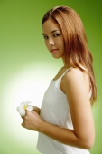 Young woman holding Frangipani flower, looking at camera - Alex Microstock02