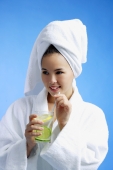 Young woman wearing white bathrobe and towel turban, holding drink - Alex Microstock02