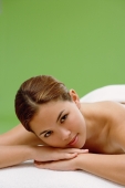 Young woman lying on massage table, head on arms - Alex Microstock02