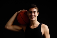 Man holding basketball on shoulder, smiling at camera - Alex Microstock02