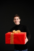 Man in black turtleneck, holding wrapped present - Alex Microstock02