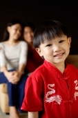 Young boy smiling at camera, parents in background - Alex Microstock02