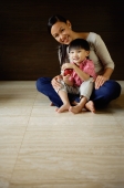 Mother with young son sitting on floor, smiling at camera - Alex Mares-Manton