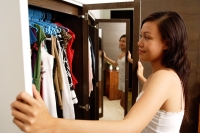 Woman looking into wardrobe full of clothes - Alex Mares-Manton