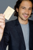 Man holding credit card, smiling - Yukmin