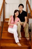 Couple sitting on stairs, looking at camera - Alex Mares-Manton