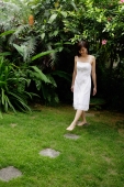 Woman in white dress stepping on stones in garden - Alex Mares-Manton