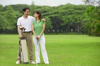Couple on golf course, smiling at each other - Alex Mares-Manton