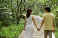 Mature couple walking in park, holding hands, rear view - Alex Mares-Manton