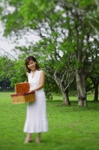 Woman holding picnic basket, smiling - Alex Mares-Manton
