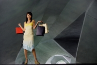 Woman standing in tunnel, carrying shopping bags - Yukmin