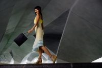 Woman in dress and platform shoes, carrying shopping bag - Yukmin