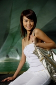 Woman in white tube top and pants, carrying gold bag - Yukmin