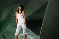 Woman in white tube top and white pants, hands in pockets, looking away - Yukmin