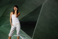 Woman in white tube top and white pants, using mobile phone - Yukmin