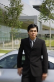 Businessman leaning on car, looking at camera - Alex Mares-Manton
