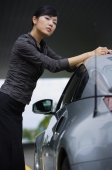 Woman leaning on car, looking at camera - Alex Mares-Manton