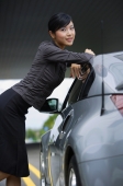 Woman leaning on car, smiling at camera - Alex Mares-Manton