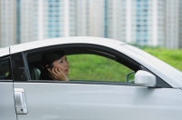 Woman sitting in silver sports car, using mobile phone - Alex Mares-Manton