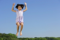 Girl jumping in mid air, smiling - Alex Mares-Manton