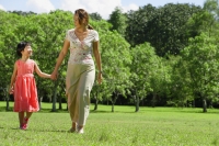 Mother and daughter, holding hands, walking in park - Alex Mares-Manton