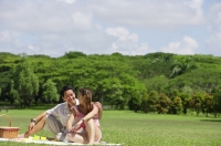 Couple sitting in park, having a picnic - Alex Mares-Manton