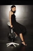 Young woman in black dress sitting on stool - Yukmin